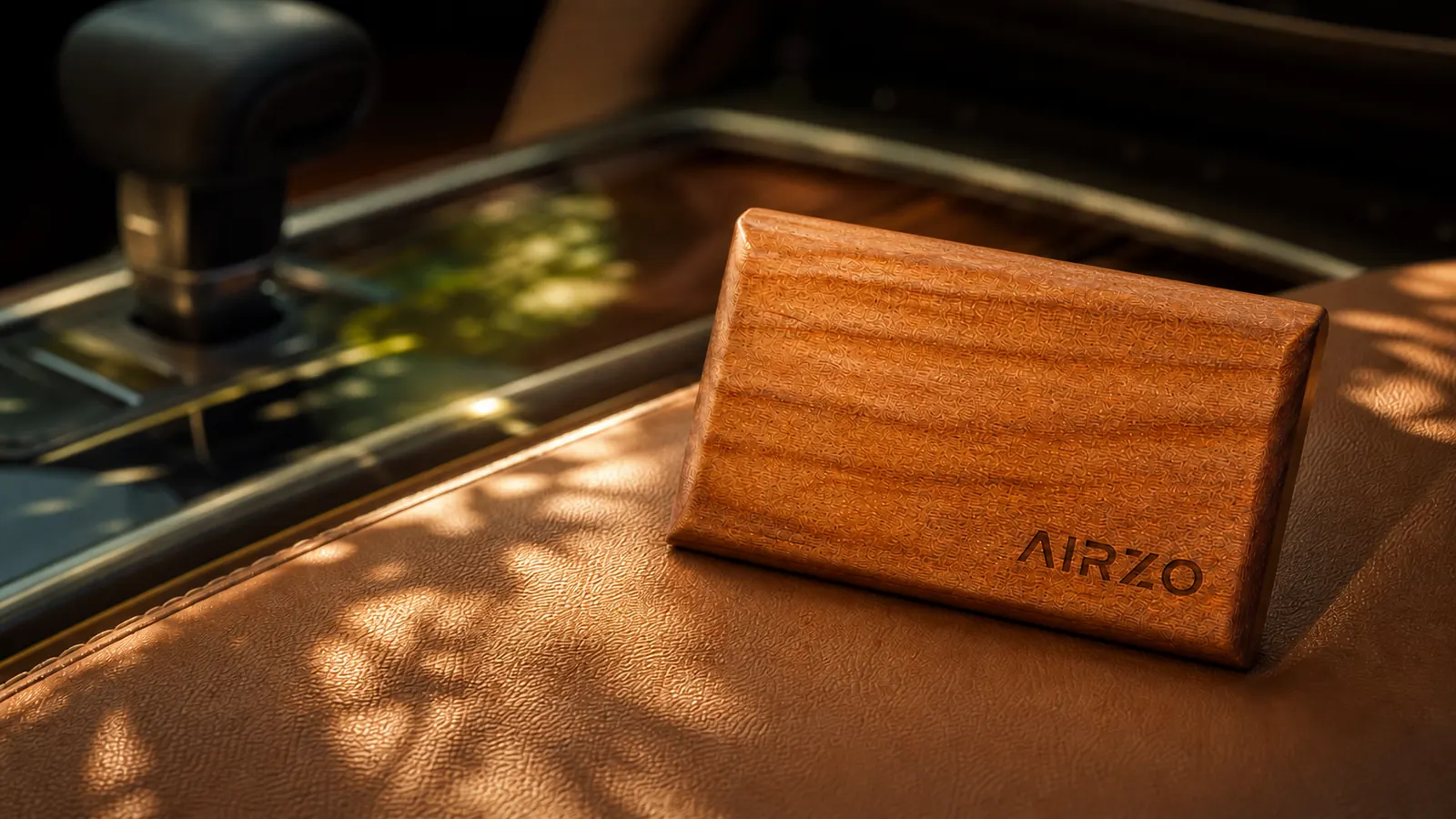 AIRZO wooden car freshener resting on a warm tan leather car interior in golden afternoon light